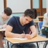 Jovenes realizando examen en un aula