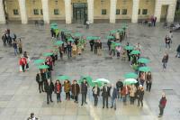 Imagen del lazo humano con paraguas verdes en la plaza del Ayuntamiento